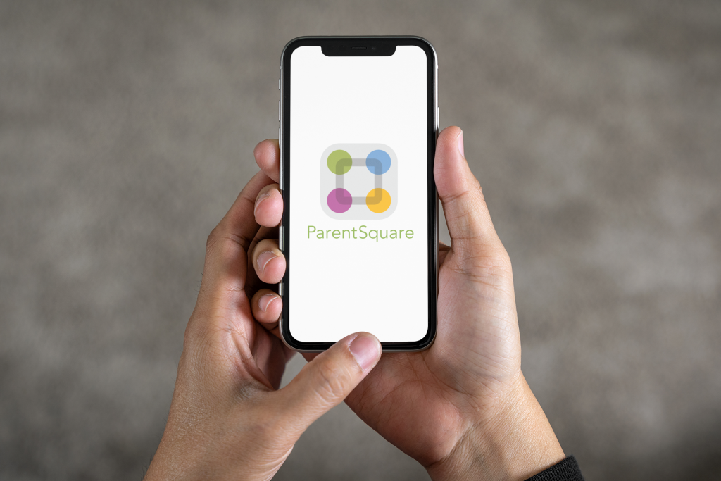 A person holds a smartphone displaying the ParentSquare app, featuring a logo with colorful circles.